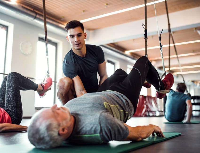 Coach working with TRX machine